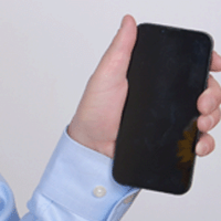A hand holds a smartphone.